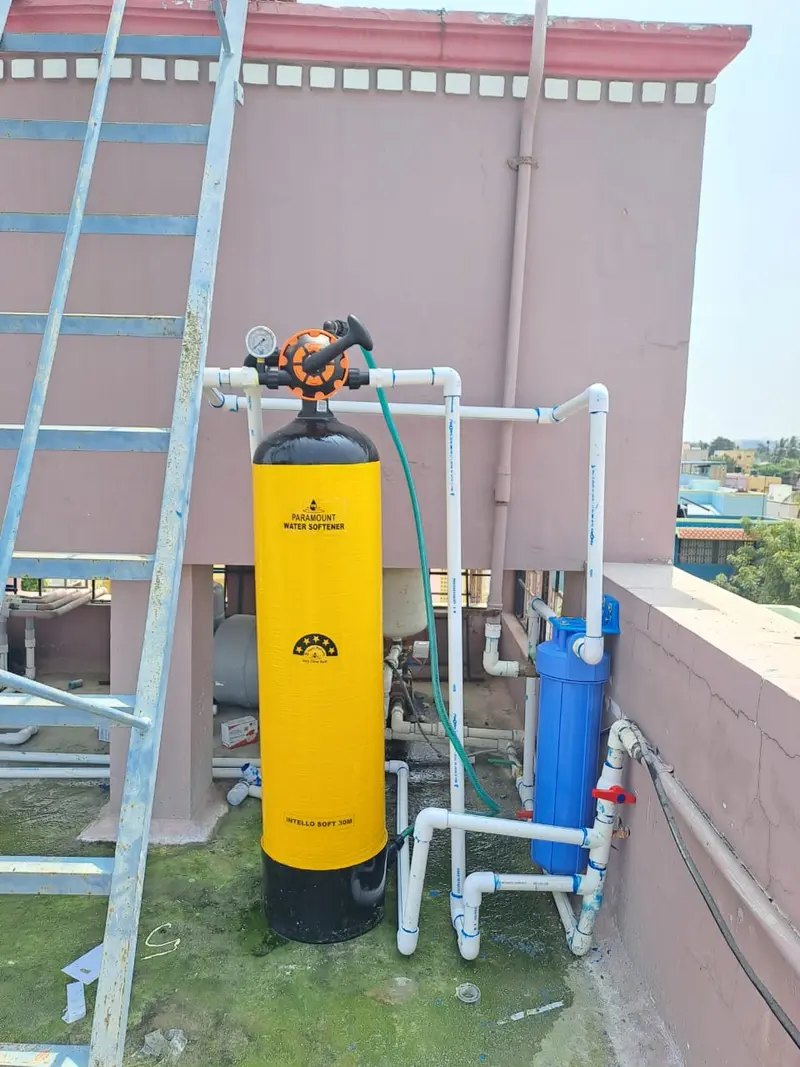 Evergreen Aqua softener vessel and blue pre-filter installed on a terrace